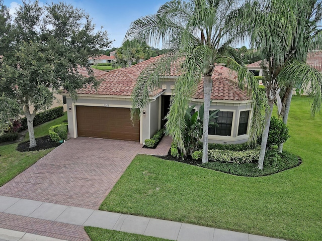 mediterranean / spanish house featuring a front yard and a garage