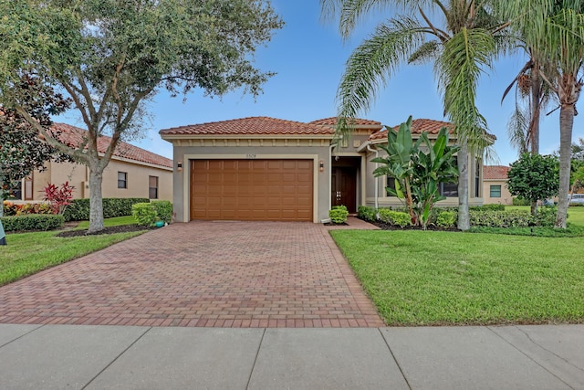 mediterranean / spanish-style home featuring a front yard and a garage