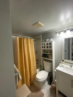 full bathroom featuring toilet, vanity, and shower / bath combination with curtain