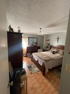 bedroom featuring parquet floors and a textured ceiling