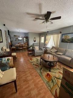 living room with ceiling fan and a textured ceiling