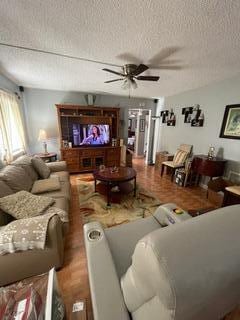 living room featuring a textured ceiling and ceiling fan