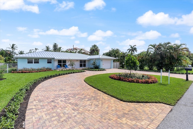 ranch-style house featuring a garage and a front lawn