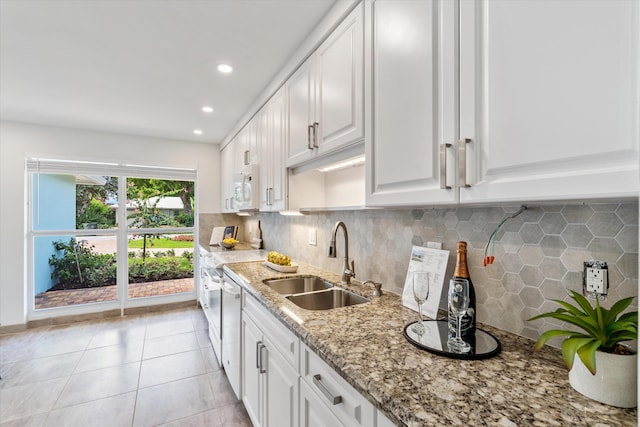 kitchen with white appliances, white cabinets, tasteful backsplash, sink, and light tile patterned floors