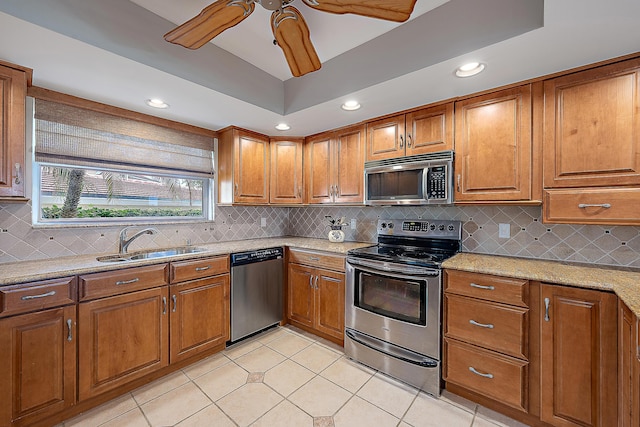 kitchen featuring sink, light tile patterned floors, stainless steel appliances, light stone countertops, and decorative backsplash