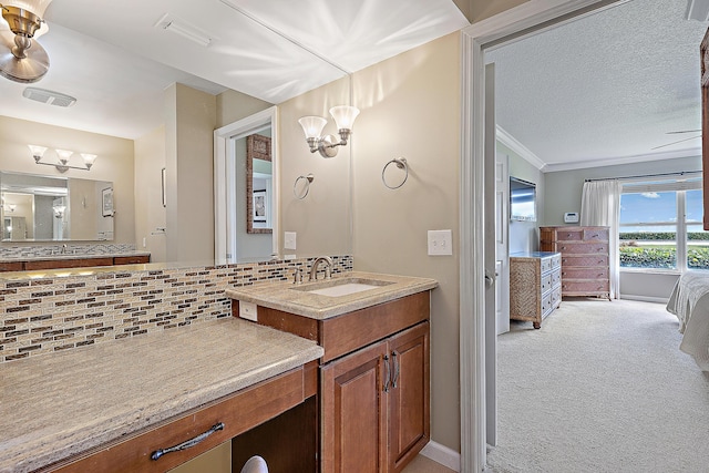 bathroom with crown molding, an inviting chandelier, vanity, a textured ceiling, and decorative backsplash