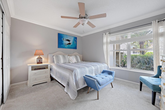 carpeted bedroom featuring crown molding, ceiling fan, and a textured ceiling