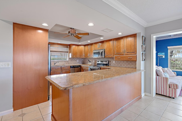 kitchen featuring appliances with stainless steel finishes, ornamental molding, light tile patterned flooring, decorative backsplash, and kitchen peninsula