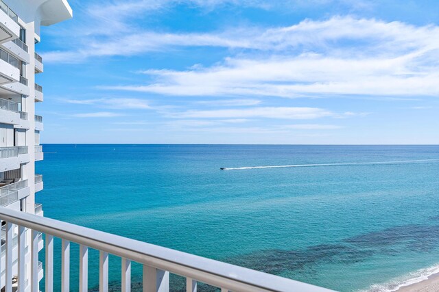 balcony featuring a beach view and a water view