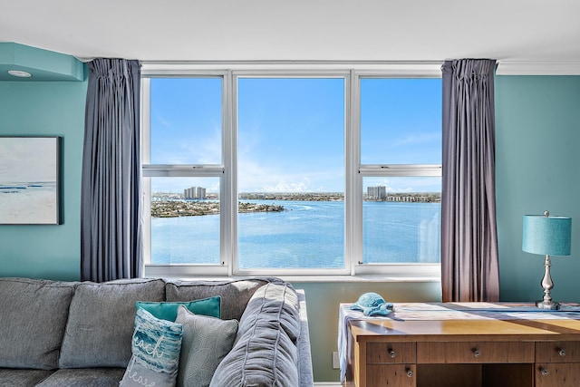 living room featuring crown molding and a water view