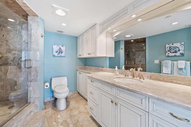 bathroom featuring toilet, a stall shower, and vanity