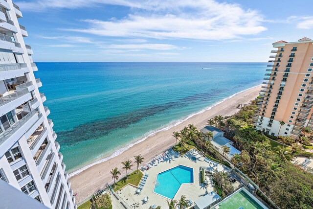 view of swimming pool with a water view and a beach view