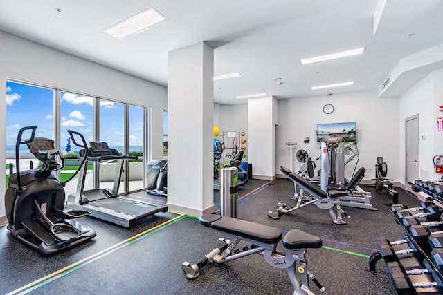 exercise room with baseboards and visible vents