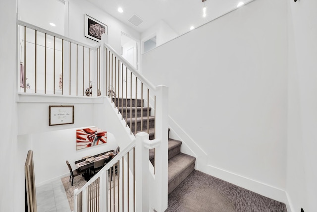 stairway with visible vents, baseboards, and recessed lighting