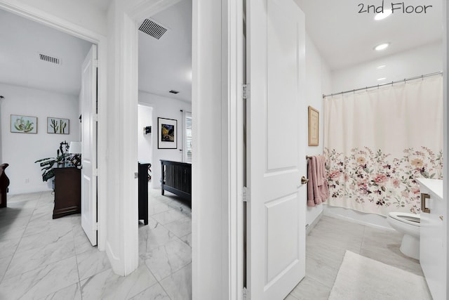 full bath with toilet, marble finish floor, visible vents, and shower / bath combo with shower curtain