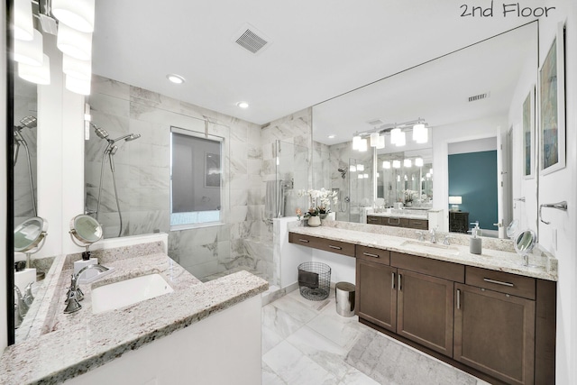 bathroom with marble finish floor, visible vents, a sink, and a marble finish shower