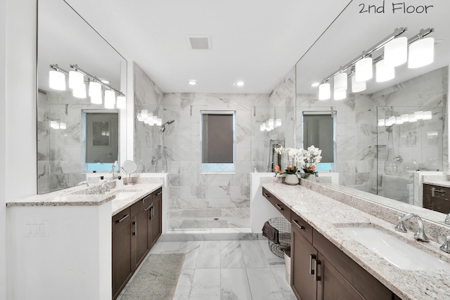 full bathroom with marble finish floor, visible vents, a sink, and a stall shower