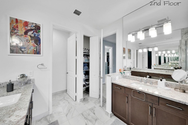 full bathroom featuring two vanities, a sink, visible vents, baseboards, and marble finish floor