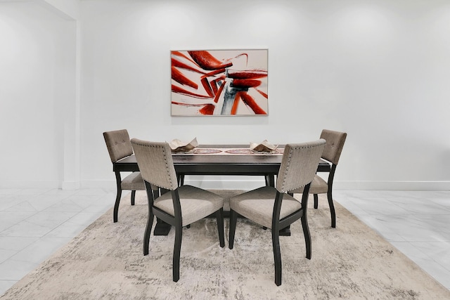 dining area featuring marble finish floor and baseboards