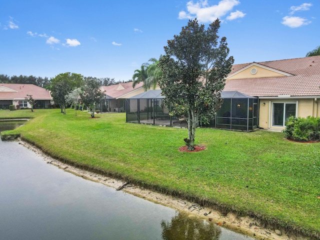 view of yard with a water view and glass enclosure