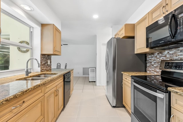 kitchen featuring black appliances, light brown cabinetry, sink, light stone counters, and light tile patterned floors