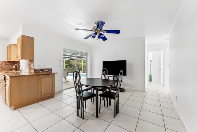 dining space with ceiling fan, light tile patterned flooring, and sink