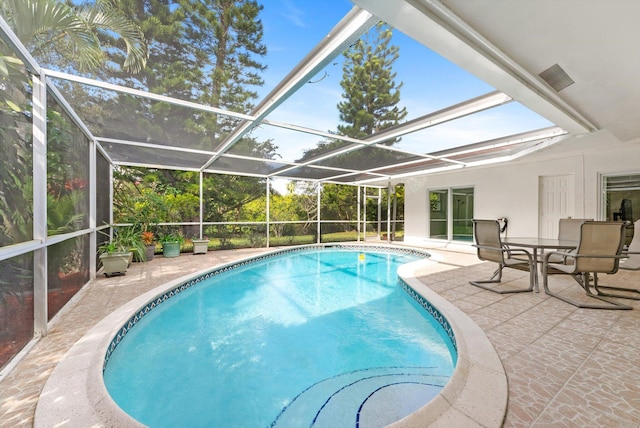 view of pool featuring glass enclosure and a patio