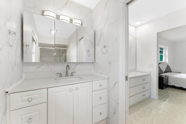 bathroom featuring a shower with shower door and vanity