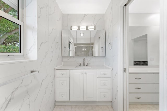 bathroom with vanity, plenty of natural light, and a shower with door