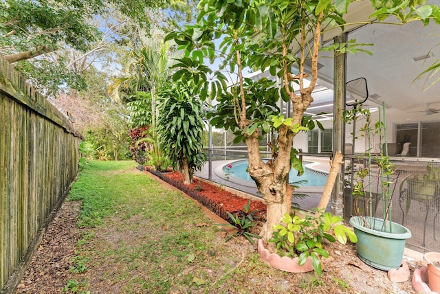 view of yard with a fenced in pool and glass enclosure