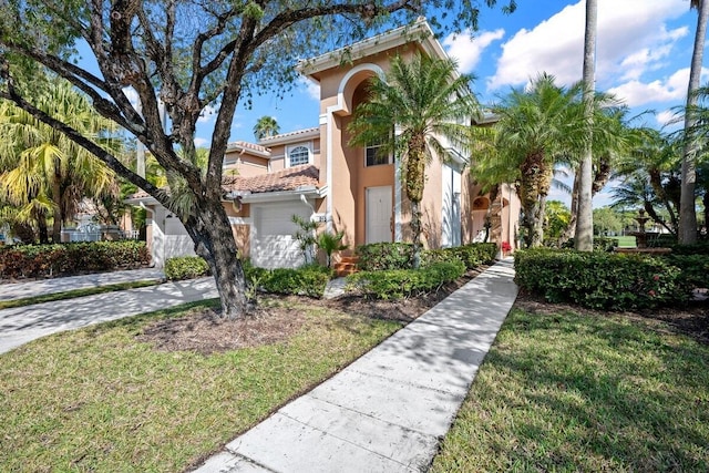 mediterranean / spanish home with a garage and a front lawn