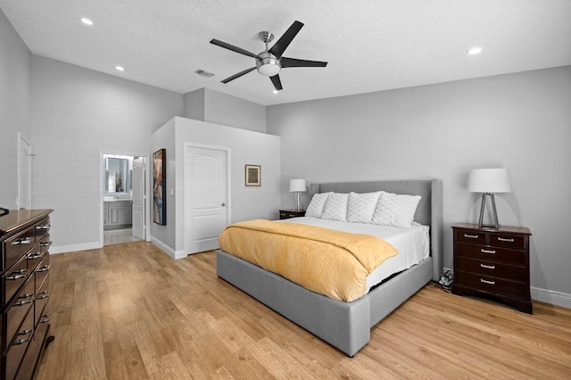 bedroom featuring ceiling fan, connected bathroom, a textured ceiling, and light wood-type flooring