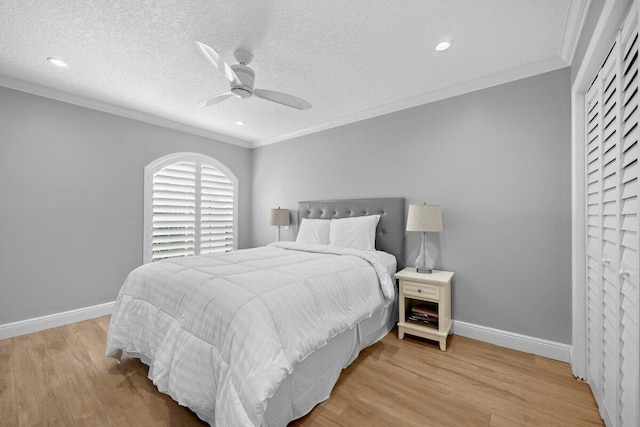 bedroom with ceiling fan, light wood-type flooring, and a textured ceiling