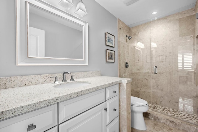 bathroom with an enclosed shower, vanity, and toilet