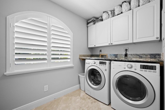 washroom with light tile patterned flooring, cabinets, and washer and dryer