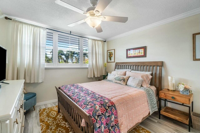 bedroom featuring ceiling fan, a textured ceiling, crown molding, and light wood-type flooring