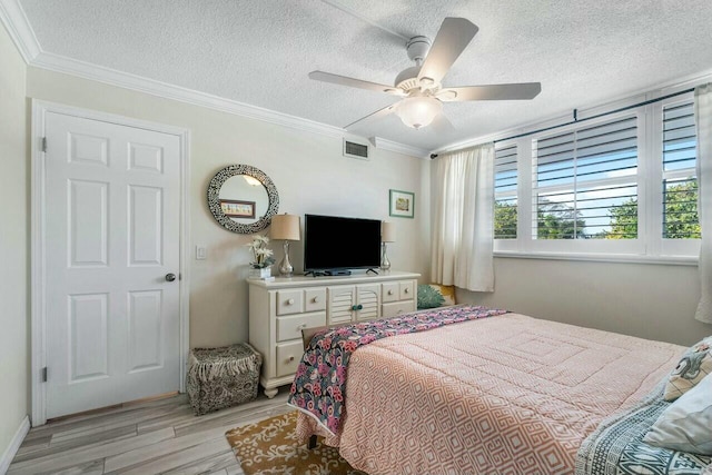 bedroom with ceiling fan, a textured ceiling, and crown molding