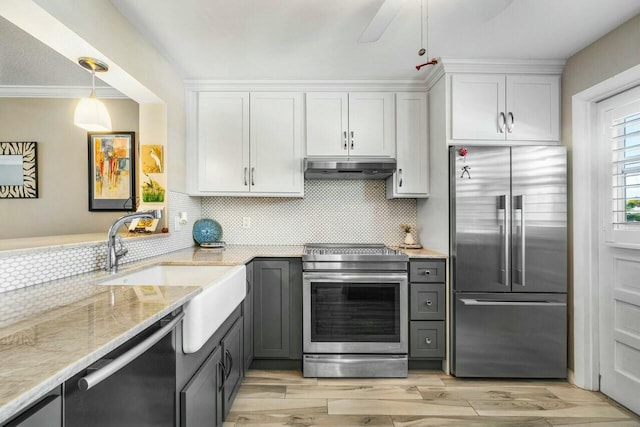 kitchen with appliances with stainless steel finishes, white cabinetry, tasteful backsplash, hanging light fixtures, and crown molding