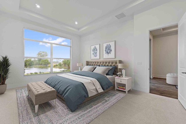 205 SE Via Sangro, Port Saint Lucie, FL 34952 - bedroom featuring a tray ceiling, a water view, carpet floors, baseboards, and recessed lighting