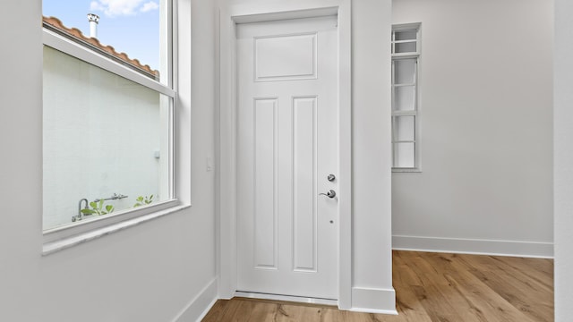 205 SE Via Sangro, Port Saint Lucie, FL 34952 - doorway to outside featuring baseboards, wood finished floors, and healthy amount of natural light