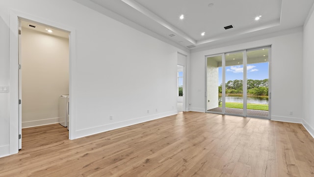 205 SE Via Sangro, Port Saint Lucie, FL 34952 - spare room with light wood-style flooring, a raised ceiling, baseboards, recessed lighting, and a water view
