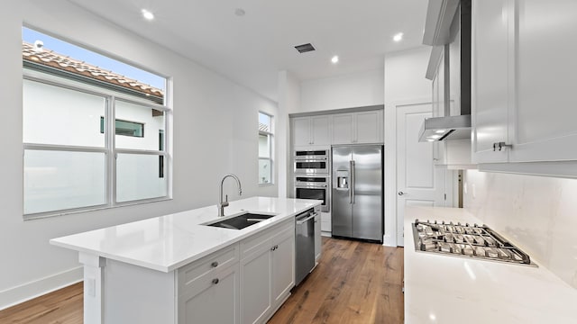 205 SE Via Sangro, Port Saint Lucie, FL 34952 - kitchen featuring appliances with stainless steel finishes, a sink, wood finished floors, light countertops, and an island with sink