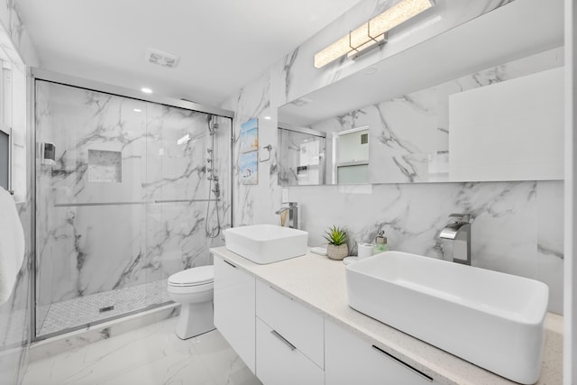 bathroom with vanity, a shower with door, tile walls, and toilet