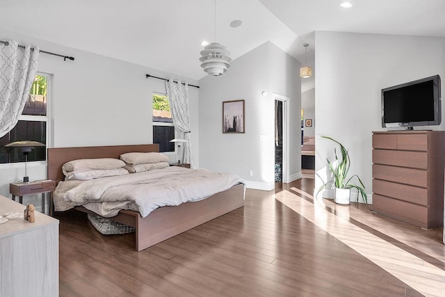 bedroom with lofted ceiling, hardwood / wood-style floors, and multiple windows