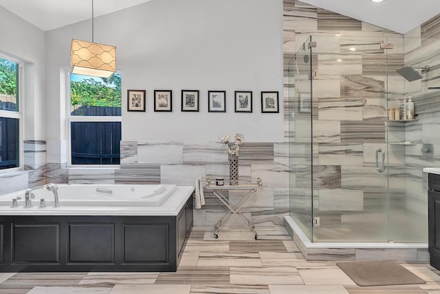 bathroom with lofted ceiling and shower with separate bathtub