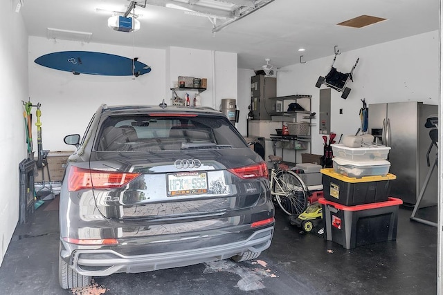 garage featuring stainless steel refrigerator with ice dispenser, a garage door opener, and electric panel