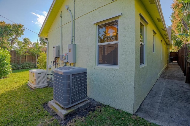 view of side of property featuring central AC and a lawn