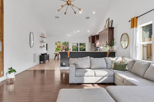 living room with dark hardwood / wood-style flooring, high vaulted ceiling, and a chandelier