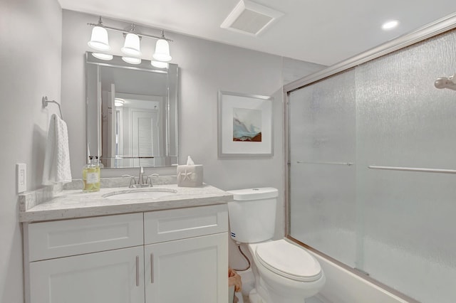 bathroom with an enclosed shower, vanity, and toilet