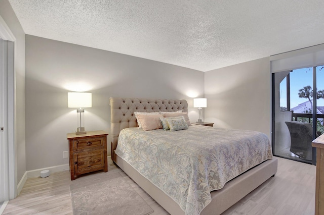 bedroom featuring light wood-type flooring and a textured ceiling